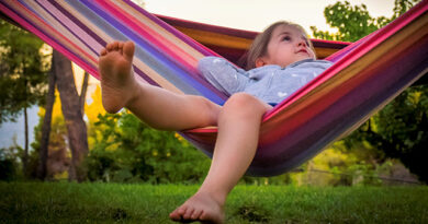 young girl in a colourful hammock